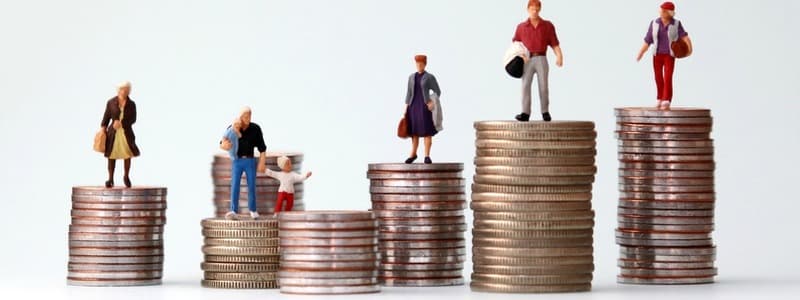 Miniature people standing on piles of different heights of coins. The concepts of person and wealth.