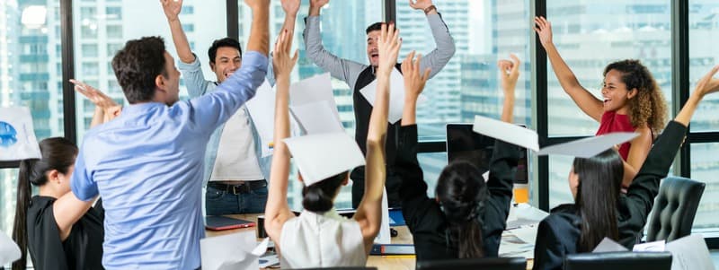 Multiethnic diverse Group of business people celebrating by throwing papers in the air and having fun in office.Happy business people cheering together,celebrate project success